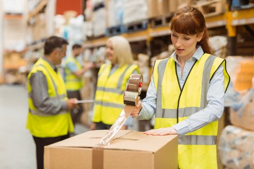 Warehouse workers preparing a shipment in a large warehouse