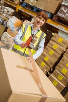 Smiling warehouse workers preparing a shipment in a large warehouse