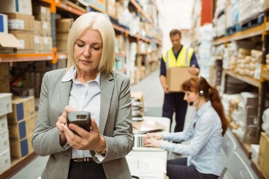 Focused warehouse manager using handheld in a large warehouse
