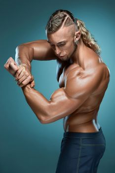 torso of attractive male body builder on blue background.