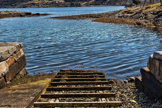 A boat landing with wooden sleepers by a Norwegian fjord