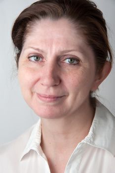 Portrait of an adult woman in a white blouse. Closeup.