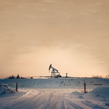 Pump jack on a sky background. Toned. Square format.