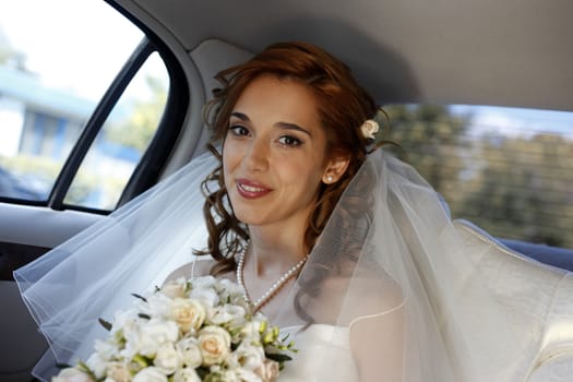 The beautiful smiling bride in the automobile