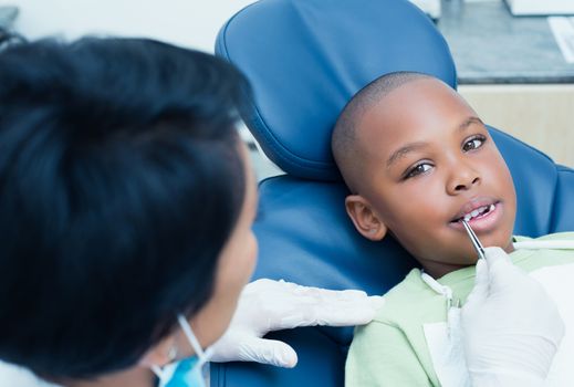 Close up of dentist examining a boys teeth in the dentists chair