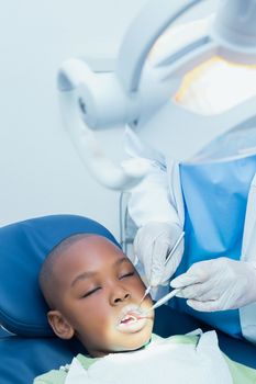 Close up of boy having his teeth examined by a dentist