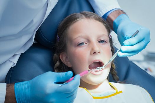 Close up of girl having her teeth examined by a dentist