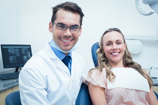 Dentist examining young womans teeth in the dentists chair