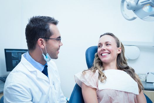 Dentist examining young womans teeth in the dentists chair