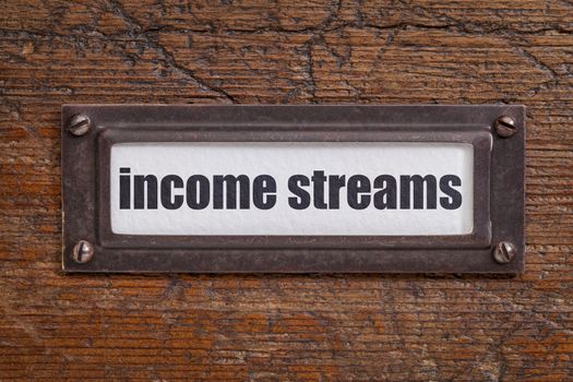 income streams   - file cabinet label, bronze holder against grunge and scratched wood