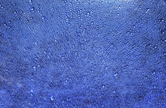 Closeup pattern of water drops on blue background