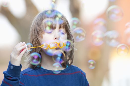 Boy with Blond Hair Blowing Bubbles Outdoor
