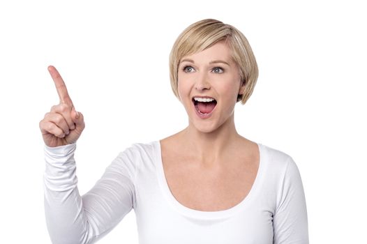 Surprised woman pointing her finger to upwards