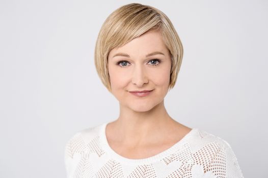 Relaxed woman posing to camera over grey