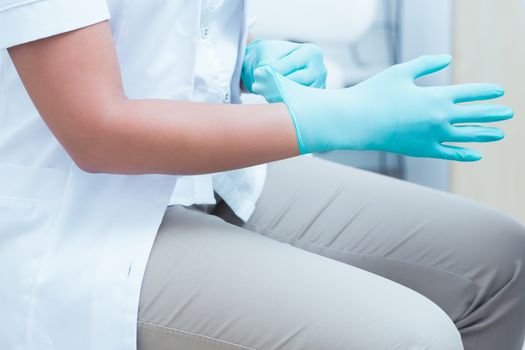 Close up mid section of female dentist wearing surgical glove