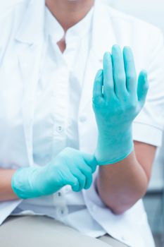 Close up mid section of female dentist wearing surgical glove