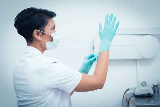 Side view of female dentist wearing surgical glove