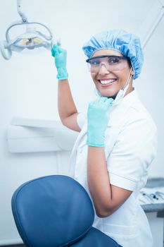 Portrait of female dentist wearing surgical cap and safety glasses