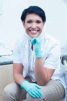 Portrait of confident female dentist with hand on chin