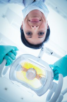 Low angle portrait of female dentist adjusting light