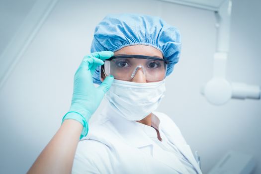 Portrait of female dentist wearing surgical mask and safety glasses