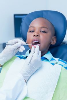 Close up of boy having his teeth examined by a dentist