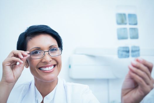 Portrait of happy female dentist holding x-ray