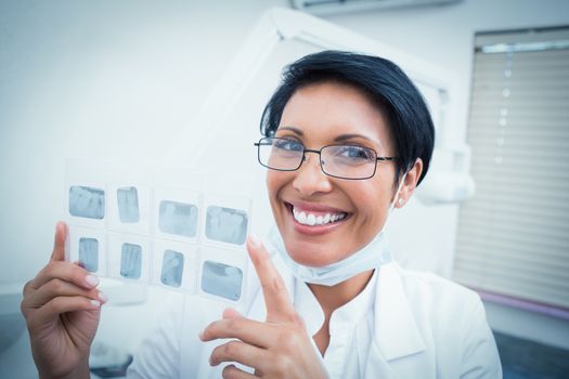 Portrait of happy female dentist holding x-ray