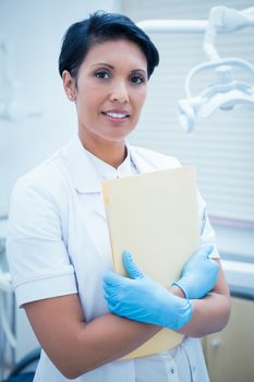 Portrait of female dentist holding reports