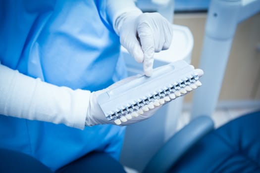 Close up mid section of female dentist holding teeth model