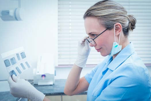 Side view of concentrated female dentist looking at x-ray