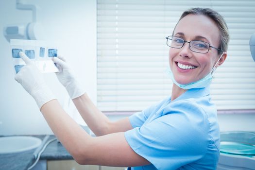 Portrait of young female dentist holding x-ray