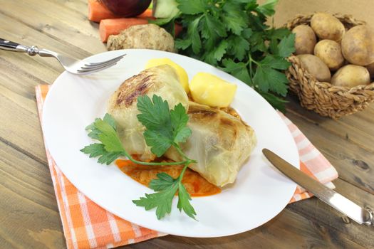 braised cabbage roulade with potatoes and sauce on a napkin