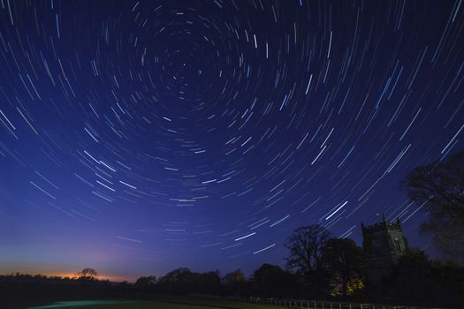 Astronomy - Star Trails in early Spring above a village church in a small village in North Yorkshire in the United Kingdom.