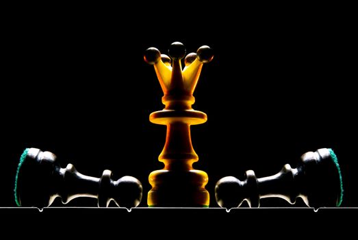 Chessmen on a chess board. A dark background and art illumination.