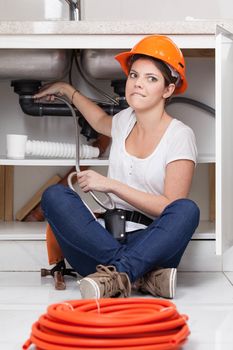 Fun woman sitting repairing the pipe