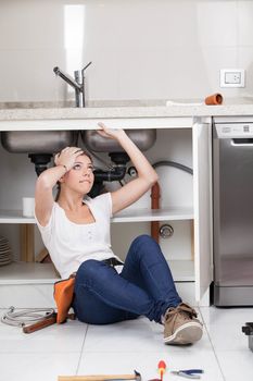 Woman working in the pipe of the kitchen