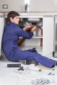 Plumber repairing the pipe of the kitchen sink