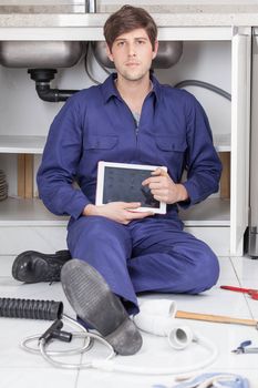 Serious plumber with his tablet