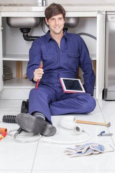 Plumber holding his wrench and his tablet