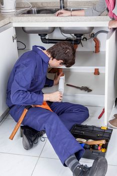 Plumber repairing the sink of the kitchen