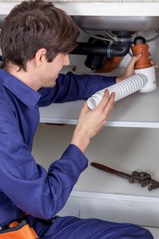 Plumber fixing the sink of the kitchen