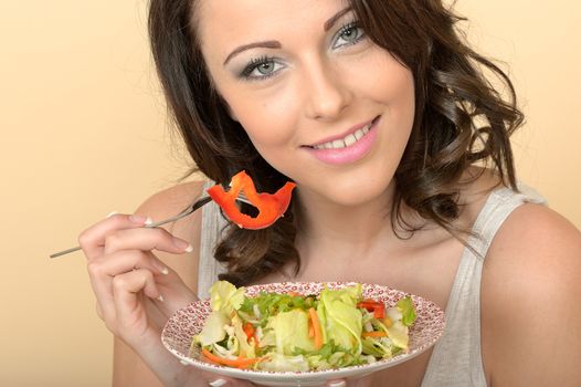 Attractive Beautiful Young Woman Looking at the Camera Eating and Enjoying a Mixed Green Salad