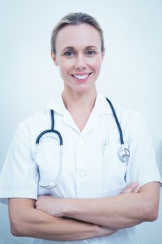 Portrait of smiling young female dentist with arms crossed