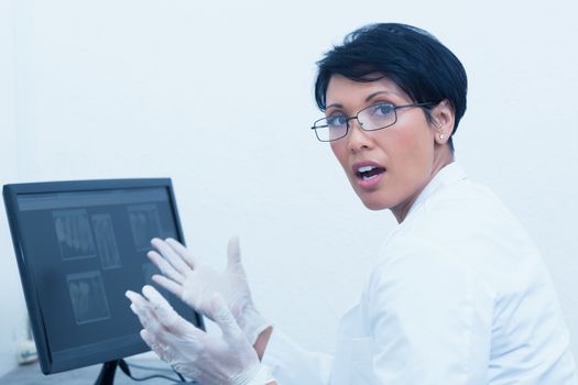 Portrait of female dentist with x-ray on computer