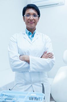 Portrait of confident female dentist standing with arms crossed