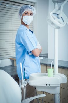 Portrait of female dentist wearing surgical mask with arms crossed