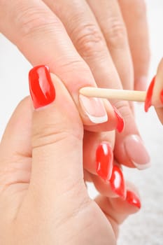 beauty salon, manicure applying, cleaning the cuticles with wooden stick