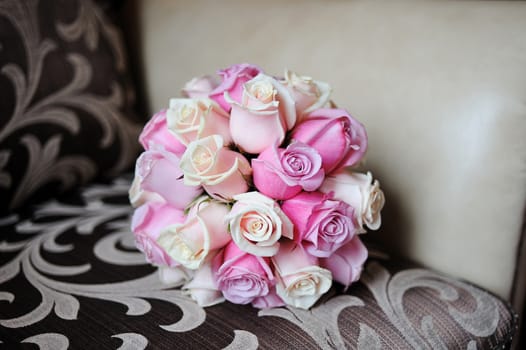 Wedding bouquet of pink roses lying on the sofa