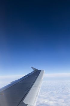 Airbus A320 Wing Against Blue Sky and Clouds 
